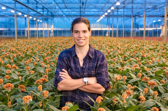 Carolien van den Biggelaar in greenhouse with flowers